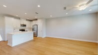 This two-story home in Jacksonville, FL offers a well-designed layout spread across two floors. The main level houses the kitchen and living area, along with an attached garage featuring an automatic opener and a clean concrete floor. The kitchen is a standout, boasting white shaker cabinetry, a large white quartz island with an integrated sink, subway tile backsplash, stainless steel appliances, and light wood-look flooring that flows throughout the main level. A dedicated laundry room with side-by-side washer and dryer is finished with elegant marble-style tile.

Upstairs, the primary bedroom impresses with soaring vaulted ceilings, a ceiling fan, plush carpet, and a triple window offering views of the surrounding greenery. Its en-suite bathroom features a sleek white vanity with ample drawer storage, marble-style floor and shower tile, and a glass-enclosed walk-in shower. A spacious walk-in closet with wire shelving provides generous storage. Two additional carpeted bedrooms, each with ceiling fans and natural light, share a full bathroom complete with a marble-style tub surround, matching tile flooring, and a white vanity. The home's neutral palette and modern finishes create a clean, contemporary ambiance throughout.