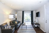 This single-floor residence offers a thoughtfully designed layout that balances comfort and functionality across multiple rooms. The living area serves as the heart of the home, featuring rich hardwood-style flooring, a sliding glass door that floods the space with natural light and opens to an outdoor balcony, and a textured ceiling that adds character throughout.

The kitchen is well-equipped with a full suite of stainless steel appliances, including a refrigerator, dishwasher, microwave, and range. Crisp white cabinetry with dark countertops provides ample storage and workspace, while a ceiling fan ensures comfortable airflow. The hardwood-style flooring continues seamlessly from the living area into the kitchen.

The bedrooms are carpeted and offer a quiet retreat, each with windows dressed in dark curtains for privacy and light control. One bedroom features a dedicated workspace nook with a wall-mounted shelf, making it ideal for study or remote work.

The bathrooms are clean and functional, each featuring a tub-shower combination with modern fixtures and tiled flooring. Neutral tones throughout the residence create a cohesive, calming aesthetic that is easy to personalize. Overall, this space offers a practical and comfortable living environment suitable for a range of lifestyles.
