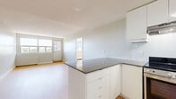 Located on Wellington Street West in Ottawa's vibrant Hintonburg neighbourhood, this 2-bedroom, 1-bathroom unit offers a clean, modern living environment across a single floor. Light-toned hardwood flooring runs throughout, lending a cohesive and contemporary feel to every room. The open-concept kitchen and living area form the heart of the unit. The kitchen is outfitted with sleek white cabinetry, dark countertops, a white subway tile backsplash, and stainless steel appliances including a range, dishwasher, and refrigerator. A peninsula with built-in storage provides additional workspace and casual seating options. The living area is bright and airy, with large windows framing views of the surrounding neighbourhood and allowing generous natural light to fill the space. Both bedrooms are well-proportioned, with the primary bedroom featuring a broad window wall that floods the room with daylight. A hallway with closet space connects the bedrooms to the rest of the unit. The bathroom is finished in a clean, all-white palette, featuring a full soaker tub with tiled surround, a white vanity, and a large mirror. The overall design emphasizes simplicity and functionality, making efficient use of the available space.