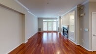 This single-floor residence offers a thoughtfully designed layout that balances comfort and functionality throughout. The main living area makes an immediate impression with gleaming rich hardwood floors, crown molding, and a classic fireplace flanked by built-in shelving. A set of glass-paned doors floods the space with natural light and provides a view to the outdoors, creating a bright and welcoming ambiance. An adjacent dining or flex area continues the hardwood flooring and crown molding detailing, maintaining a cohesive aesthetic.

The kitchen is well-equipped with white shaker-style cabinetry, dark granite countertops, and a full suite of stainless steel appliances including a refrigerator, range, and over-the-range microwave. Warm hardwood floors extend into this space, tying it seamlessly to the main living areas.

The bedrooms offer plush carpeting, neutral wall tones, and windows fitted with blinds that allow for adjustable natural light. Each room provides a calm, versatile setting suitable for a variety of uses.

The bathrooms are finished with light wood vanity cabinetry, dark granite countertops, and light tile flooring. One bathroom features a walk-in glass shower, while another includes a window that brings in additional natural light, enhancing the clean, functional design throughout.