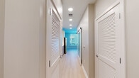 Located at 2008–2032 N Beauregard St in Alexandria, Virginia, this modern single-floor unit offers a clean, contemporary design throughout. Light wood-tone flooring flows seamlessly across every room, creating a cohesive and airy atmosphere.

The kitchen is well-appointed with stainless steel appliances, including a range, over-the-range microwave, and dishwasher. Sleek two-tone cabinetry — white upper cabinets and light wood lower cabinets — pairs with bright white subway tile backsplash and crisp white countertops, delivering a polished, functional workspace with ample storage.

A central hallway connects the main living areas and features recessed lighting overhead and louvered bi-fold closet doors, optimizing storage while maintaining a tidy aesthetic. A standout architectural detail is the frosted-glass sliding barn door, which adds a modern industrial accent while allowing diffused light to pass between spaces.

The bedroom is generously proportioned, featuring a large window that admits abundant natural light and offers views of the surrounding neighborhood. The bathroom includes full-size soaking tub and shower combination with floor-to-ceiling taupe tile surround, a toilet, and warm wood-tone vanity cabinetry. Recessed lighting throughout the unit ensures consistent, well-distributed illumination. The overall design is modern, minimalist, and move-in ready.