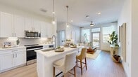 Located at 550 W 100 S in downtown Salt Lake City, this thoughtfully designed 2-bedroom, 2-bathroom residence offers a clean, contemporary aesthetic throughout. The open-concept layout seamlessly connects the kitchen, dining area, and living room, all finished with light wood-style flooring and a bright, neutral palette. The kitchen is well-appointed with white shaker cabinetry, stainless steel appliances, a subway tile backsplash, and a central island with pendant lighting and bar seating. The living room is bathed in natural light from large windows and a glass door that opens to a private balcony, offering outdoor views of the surrounding cityscape. A ceiling fan adds comfort to this welcoming gathering space. The primary bedroom features natural light from a wide window, a ceiling fan, and access to a spacious walk-in closet with built-in shelving. The second bedroom showcases a distinctive geometric wood accent wall, adding warmth and character. Both bathrooms are finished with white vanities, wood-look flooring, and tiled tub-shower combinations. Each bedroom is served by its own dedicated closet, providing generous storage throughout. The overall ambiance is modern, light-filled, and cohesive.