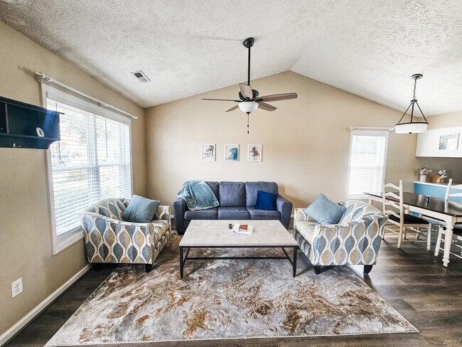 Sala de estar con techo abovedado y ventilador. - 2127 Winter Moss Ln