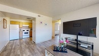 Located at 2060 N Trekell Rd in Casa Grande, Arizona, this single-floor, 3-bedroom, 1-bathroom unit offers a practical and comfortable layout. Wood-look plank flooring runs throughout, providing a cohesive and easy-to-maintain finish across every room.

The combined kitchen and living area serves as the heart of the unit. The living room features a large window that brings in natural light and offers outdoor views, complemented by a textured ceiling. The kitchen is equipped with light wood cabinetry, a full-size refrigerator, an electric range, and ample counter space arranged in an efficient layout.

The unit includes three bedrooms, each featuring the same wood-look flooring and textured ceilings. The primary bedroom is a well-sized retreat with a large window providing natural light and outdoor views. The second bedroom includes a built-in closet and a window overlooking the outdoor area. The third bedroom connects conveniently to the main living space via a short hallway.

The single full bathroom is clean and functional, featuring a tiled shower-tub combination with a curtain, toilet, and a simple, efficient layout.

A connecting hallway ties all rooms together, maintaining an organized flow throughout the unit. Overall, the space presents a straightforward, functional design well-suited for everyday living in Casa Grande.