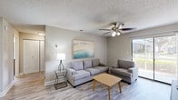 Located at 604 Laurel Lake Ct in Orlando, Florida, this well-appointed 2-bedroom, 2-bathroom residence offers a comfortable and functional single-floor layout. The open-concept living, dining, and kitchen area forms the heart of the home, bathed in natural light from a sliding glass door that leads to a private balcony. The living room features light wood-look flooring, a ceiling fan, and a neutral color palette that creates a bright, welcoming atmosphere throughout. The galley-style kitchen is equipped with warm wood cabinetry, granite-style countertops, a breakfast bar, stainless steel appliances, and ample storage, flowing seamlessly into the adjacent dining area. Both bedrooms are generously sized, with the primary bedroom offering a walk-in closet and its own dedicated bathroom. The second bedroom also benefits from closet space and easy access to the second full bathroom. Each bathroom is finished with wood-toned vanity cabinetry, granite countertops, and light tile flooring. Additional highlights include five closets for abundant storage, a dedicated laundry area, a utility room, and a hallway connecting the private spaces. The consistent light flooring and neutral tones throughout lend the home a cohesive, modern feel.