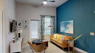 Located in Austin's lively East 6th Street neighborhood, this contemporary 2-bedroom, 2-bathroom residence blends urban design with modern comfort across a single thoughtfully laid-out floor. Polished concrete floors flow throughout the space, lending an industrial-chic character that ties each room together seamlessly.

The open-concept kitchen and living area serves as the heart of the home. The kitchen is equipped with stainless steel appliances, rich dark wood cabinetry extending to the ceiling, granite countertops, a mosaic tile backsplash, pendant lighting, and a breakfast bar with seating — ideal for both everyday dining and entertaining. The adjoining living room features soaring ceilings, a bold teal accent wall, abundant natural light from multiple windows, and a ceiling fan overhead.

The spacious primary bedroom offers elevated ceilings, a walk-in closet, and natural light through large windows. The second bedroom is well-proportioned with ample window coverage. Both bathrooms are finished with dark wood vanities, granite countertops, and large mirrors. The primary bath features a deep soaking tub with full tile surround, while the second bath is equally well-appointed. A hallway and dedicated closet complete the functional layout of this stylish Austin residence.
