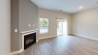 Located at 6420 Harvey St in Muskegon, Michigan, this thoughtfully designed two-story home offers 2 bedrooms and 3 bathrooms across two well-proportioned floors. The main level features an open-concept layout connecting the living room, dining area, and kitchen. The living room is a standout space, highlighted by a gas fireplace set against a neutral accent wall and large sliding glass doors that flood the room with natural light and provide direct outdoor access. The kitchen is outfitted with two-tone shaker cabinetry in white and gray, white quartz countertops, a subway tile backsplash, and stainless steel appliances including a gas range. A convenient half bathroom and dedicated laundry room with full-size washer and dryer complete the main level. Light wood-look flooring runs throughout the main floor, complementing the clean, contemporary aesthetic. Upstairs, both bedrooms feature plush carpet, neutral walls, and generous windows that invite natural light and outdoor views. The primary bedroom is a comfortable retreat with ample square footage. Three bathrooms serve the home, including a full bath with a walk-in shower finished in crisp white. Multiple closets and hallways provide practical storage throughout. The home's clean lines, neutral palette, and modern finishes create a bright, move-in-ready living environment.