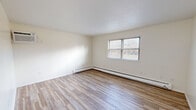 Located at 119 S Washington St in Plainville, Connecticut, this 2-bedroom, 1-bathroom unit offers a thoughtfully laid-out single-floor plan designed for comfortable everyday living. The main living area is generously sized, featuring light wood-style plank flooring, crisp white walls, and a textured ceiling. Natural light enters through a large window fitted with blinds, while a baseboard heating system runs along the perimeter, ensuring warmth throughout the colder months. The entry door opens directly into this bright, open living space.

The spacious primary bedroom continues the light flooring theme seen in the living area and is served by its own baseboard heat and window. The second bedroom is finished with soft carpeting, a natural-light window, and a full-panel double closet, providing ample storage. Both bedrooms maintain a clean, neutral palette throughout.

The kitchen, visible in the floor plan, is equipped with cabinetry and a stainless steel range, with space for a stackable washer unit conveniently located nearby. The bathroom is a standout feature, showcasing large-format marble-look porcelain tile surrounding a full soaking tub with brushed nickel fixtures, adding a polished, modern touch. Overall, the unit presents a clean, move-in-ready interior with functional and well-distributed living spaces.
