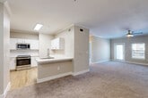 Located in Pearland, TX, this two-story residence offers 3 bedrooms, 3 bathrooms, and a thoughtfully designed layout across two floors. The main living level hosts the majority of the space, where an open-concept floor plan connects the kitchen and living area seamlessly. The kitchen is outfitted with white shaker-style cabinetry, a subway tile backsplash, stainless steel appliances including a refrigerator, range, and microwave, and a breakfast bar peninsula with a sink — all complemented by light hardwood-style flooring. The expansive living area features warm neutral carpet, crown molding, and a ceiling fan, with natural light streaming in through sliding glass doors. Each bedroom is carpeted and equipped with a ceiling fan; the bedrooms are bright and airy, with multiple windows offering outdoor views. Three closets — including a walk-in with wire shelving in the primary suite — provide ample storage. The bathrooms feature light hardwood flooring and clean, neutral finishes. A dedicated laundry room houses a full-size washer and dryer. The attached garage on the ground floor includes an automatic opener and interior stair access, adding everyday convenience to this well-appointed Pearland residence.