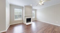 Located at 800 Lakeside Cir in Lewisville, TX, this well-appointed one-bedroom, one-bathroom residence offers a thoughtfully designed single-floor layout with warm wood-style flooring throughout. The open-concept living and kitchen area serves as the heart of the home, where the living room impresses with a classic white-mantled fireplace flanked by two large windows that flood the space with natural light and views of the surrounding greenery. A ceiling fan and crown molding add refined detail overhead. The kitchen features gray cabinetry, stainless steel appliances including a refrigerator, range, and microwave, a clean white countertop peninsula, and a sink — all ideal for everyday cooking and entertaining. A dedicated dining or flex space off the kitchen offers track lighting and an exterior door. The spacious primary bedroom includes a ceiling fan, a walk-in closet, and a sliding glass door leading to an outdoor area. The full bathroom is equipped with a tub-shower combination, a vanity with storage cabinetry, and wood-style flooring. Additional highlights include two closets, a utility room, and a layout that maximizes every square foot for comfortable, practical living.