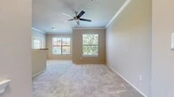 Located at 5500 Canyon Rd in Benbrook, TX, this single-story, one-bedroom, one-bathroom unit offers a thoughtfully organized floor plan that maximizes its comfortable footprint. The combined kitchen and living area serves as the heart of the home, where the kitchen features warm honey-toned cabinetry, a breakfast bar peninsula with laminate countertops, black appliances including a range, microwave, and refrigerator, and wood-look flooring. An arched architectural detail adds character to the transition between spaces. The living area extends from the kitchen, finished with plush carpeting and multiple windows fitted with horizontal blinds that allow generous natural light and outdoor views of surrounding greenery.

Crown molding and ceiling fans with light fixtures are consistent throughout the main living areas and bedroom, contributing to a clean, finished aesthetic. The spacious bedroom includes multiple windows with tree-lined views, soft carpeting, and access to a walk-in closet outfitted with wire shelving systems providing organized storage. The bathroom features wood-look flooring, overhead cabinetry, and connects directly to the hallway. Neutral gray and beige tones are used throughout, creating a cohesive and understated atmosphere across all rooms.