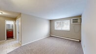 Located at 680 Smith Ct in Rocky River, OH, this one-bedroom, one-bathroom unit offers a practical and well-organized single-floor layout. The living room is a comfortable, open space finished with neutral-toned carpet and warm beige walls, bathed in natural light from a large window with views of surrounding greenery. A baseboard heating system runs along the exterior wall, and a wall-mounted air conditioning unit ensures year-round climate control. The layout flows from the living area into the bedroom, which also features soft carpeting, a window with outdoor views, and its own baseboard heating. Two closets provide ample storage throughout the unit. The kitchen is equipped with warm wood-toned cabinetry, a freestanding electric range, and durable tile flooring, offering an efficient and functional cooking space. The bathroom features a full tub-and-shower combination with classic white tiling accented by a bold black tile border, adding a clean, timeless aesthetic. Textured ceilings are present throughout the unit, contributing to the overall character of the space. The floorplan model reveals a compact yet thoughtfully arranged layout, making efficient use of every area. This unit is a straightforward, move-in-ready space in a well-established Rocky River location.