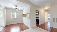 This well-appointed one-bedroom, one-bathroom residence at Chardonnay offers a thoughtfully designed single-level layout with a comfortable and functional floor plan. The combined dining and living area is bright and airy, featuring rich hardwood flooring, a ceiling fan, and multiple windows that invite abundant natural light. A pass-through window with a breakfast bar connects the living space to the galley-style kitchen, which is equipped with dark espresso cabinetry, stainless steel appliances including a refrigerator, range, microwave, and dishwasher, and light stone countertops. Hardwood flooring continues throughout the kitchen. The bedroom offers plush carpeting, dual windows with views of surrounding greenery, and a sliding closet for ample storage. The full bathroom features dark wood vanity cabinetry, a tub/shower combination, and hardwood-style flooring. A dedicated laundry room houses a full-size washer and dryer. Additional highlights include a utility room, hallway storage, and a private patio that extends the living space outdoors. The unit's neutral color palette and consistent finishes create a clean, cohesive ambiance throughout.