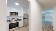 Located at 3061 Sir John's Homestead in Mississauga, Ontario, this well-appointed 2-bedroom, 2-bathroom home spans three floors, offering a functional and thoughtfully designed layout. The main living level features a spacious living room with light wood-style flooring, a white brick fireplace, and a sliding glass door that opens to a lush, tree-lined outdoor view, filling the space with natural light. The kitchen is outfitted with crisp white cabinetry, dark countertops, stainless steel appliances including an electric range with over-the-range microwave, and a window overlooking greenery. Both bedrooms offer light flooring, sliding panel closets, and windows with pleasant outdoor views. The primary bedroom provides a comfortable sense of space. The two bathrooms are finished in a clean, modern style — one featuring a subway-tiled bathtub surround, and the other with a quartz-topped vanity and large mirror. The lower level includes a utility room with laundry facilities and additional unfinished space, offering practical storage or flexible use. Throughout the home, a consistent palette of white walls, light flooring, and clean trim creates a bright, cohesive ambiance.
