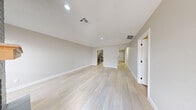 Located at 4895 Woodland Park Dr in Beaumont, TX, this single-story 2-bedroom, 4-bathroom home offers a clean, modern aesthetic with a cohesive neutral palette throughout. Light-toned wood-look flooring runs continuously across all rooms, brightening the interior and creating a seamless flow between spaces.

The living room serves as the heart of the home, highlighted by a striking floor-to-ceiling gray brick fireplace with a warm wood mantel. Natural light pours in through multiple windows fitted with blinds, enhancing the open, airy feel of the space.

The galley-style kitchen is thoughtfully designed with gray shaker cabinetry, white quartz countertops, a stainless steel sink, and a full suite of stainless steel appliances, including a range, microwave, dishwasher, and refrigerator. The layout maximizes efficiency while maintaining a stylish, contemporary look.

Both bedrooms are comfortably sized, featuring ceiling fans, neutral walls, and ample natural light. The primary bedroom offers generous proportions with dedicated closet space. Three additional closets provide abundant storage throughout the home.

The four bathrooms are finished with gray shaker vanities, white quartz countertops, undermount sinks, and matte black hardware and fixtures, delivering a polished, modern feel. A hallway connects the bedrooms and bathrooms, ensuring a practical and well-organized floor plan.