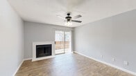 This well-appointed two-bedroom, one-bathroom home in Houston's Windmill Lakes community offers a thoughtfully designed single-floor layout. The open-concept living, dining, and kitchen area serves as the heart of the home, highlighted by wood-look flooring, a ceiling fan with light fixture, and a classic white-trimmed fireplace. Sliding glass doors lead directly to a private balcony, filling the space with natural light and outdoor views. The kitchen features crisp white cabinetry, a gray subway tile backsplash, light countertops, a breakfast bar pass-through, and black appliances including a refrigerator, range, and dishwasher, along with a dedicated pantry for added storage. Both bedrooms are comfortably sized, with the primary bedroom offering carpet flooring, a ceiling fan, and its own balcony access via sliding glass doors. The second bedroom features wood-look flooring and a ceiling fan. Three closets provide generous storage throughout. The full bathroom is clean and functional, with a white vanity, framed mirror, and a tub-shower combination. A dedicated laundry area and a hallway complete the floor plan, offering a practical and comfortable living experience.