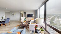 Located at 511 Four Mile Rd in Alexandria, VA, this thoughtfully designed single-floor residence offers a seamless blend of comfort and contemporary style. The expansive living room is a standout, anchored by floor-to-ceiling windows that flood the space with natural light and frame sweeping panoramic views of the surrounding Alexandria landscape. Light wood-tone flooring runs throughout, creating a cohesive and airy feel. The dining area sits adjacent to the entry, providing a welcoming space defined by clean white walls and stylish décor accents. The kitchen is well-appointed with gray cabinetry, granite-style countertops, stainless steel appliances including a gas range and over-the-range microwave, and the added convenience of an in-unit washer. The two bedrooms each offer their own distinct character — one features a bold blue accent wall with a large window overlooking scenic treetop views, while the second is highlighted by a warm orange accent wall and ample closet space with louvered doors. Both rooms include dedicated closets and light flooring. The bathroom is finished with tiled walls, a tub-shower combination, and a wood-toned vanity. This well-appointed residence offers a functional layout ideal for comfortable everyday living.