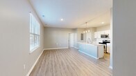 Located at 5730 Silver Falls St in Dublin, OH, this well-designed one-bedroom, one-bathroom residence offers a thoughtfully planned single-floor layout across a comfortable footprint. The open-concept living and kitchen area is anchored by light-toned luxury vinyl plank flooring, neutral gray walls, and recessed lighting that creates a bright, cohesive atmosphere. Large windows with blinds allow generous natural light to fill the living space.

The kitchen is equipped with stainless steel appliances — including a refrigerator, electric range, and over-the-range microwave — complemented by crisp white cabinetry, a classic subway tile backsplash, and a peninsula island with pendant lighting above, ideal for casual dining or meal prep. Adjacent to the kitchen, a utility area houses a stacked washer and dryer for added in-unit convenience.

The bedroom features plush wall-to-wall carpeting, a ceiling fan, and a window with exterior views. It includes direct access to a walk-in closet outfitted with wire shelving systems for organized storage.

The bathroom offers a white vanity with an undermount sink, a mirror, a shower with glass enclosure, and wood-look flooring that ties in seamlessly with the rest of the home's clean, modern aesthetic.