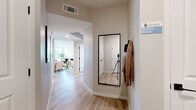 Located at 8600 N Grand Canyon Dr in Las Vegas, NV, this single-story home offers four bedrooms and three bathrooms across a thoughtfully designed floor plan. The entry hallway welcomes you with light wood-style flooring and a clean, neutral palette that carries throughout the home.

The open-concept living, dining, and kitchen area serves as the heart of the home. The living room features a ceiling fan, large windows that invite ample natural light, and views of the surrounding neighborhood framed by palm trees. The kitchen is outfitted with white shaker cabinetry, stainless steel appliances including a refrigerator, gas range, microwave, and dishwasher, complemented by a central island with bar seating and light countertops. The adjacent dining area benefits from oversized windows that flood the space with sunlight.

The primary bedroom is a comfortable retreat with plush carpeting and natural light. Additional bedrooms also feature carpet flooring and generous proportions. The three bathrooms are finished with white cabinetry, light countertops, and wood-style tile flooring; one features a tub-shower combo with subway tile surround. Two closets provide practical storage throughout. The home's consistent use of neutral tones and modern fixtures creates a cohesive and inviting atmosphere.