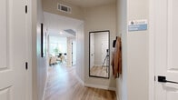 Located at 8600 N Grand Canyon Dr in Las Vegas, NV, this single-story home offers four bedrooms and three bathrooms across a thoughtfully designed floor plan. The entry hallway welcomes you with light wood-style flooring and a clean, neutral palette that carries throughout the home.

The open-concept living, dining, and kitchen area serves as the heart of the home. The living room features a ceiling fan, large windows that invite ample natural light, and views of the surrounding neighborhood framed by palm trees. The kitchen is outfitted with white shaker cabinetry, stainless steel appliances including a refrigerator, gas range, microwave, and dishwasher, complemented by a central island with bar seating and light countertops. The adjacent dining area benefits from oversized windows that flood the space with sunlight.

The primary bedroom is a comfortable retreat with plush carpeting and natural light. Additional bedrooms also feature carpet flooring and generous proportions. The three bathrooms are finished with white cabinetry, light countertops, and wood-style tile flooring; one features a tub-shower combo with subway tile surround. Two closets provide practical storage throughout. The home's consistent use of neutral tones and modern fixtures creates a cohesive and inviting atmosphere.