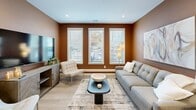Located at 26 S York Rd in Hatboro, PA, this thoughtfully designed single-floor residence offers 1 bedroom, 2 full bathrooms, a dedicated office, and in-unit laundry. The open-concept living and dining area is anchored by warm, earth-toned accent walls and large windows that flood the space with natural light. Light wood flooring flows throughout, creating a cohesive and inviting ambiance. The kitchen is a standout feature, showcasing rich dark wood cabinetry with matte black hardware, crisp white quartz countertops, stainless steel appliances, and a generous island with seating beneath elegant globe pendant lights. The primary bedroom is a serene retreat with neutral tones, a ceiling fan, ample closet access, and natural light from large windows. The office is distinctly styled with deep slate-blue walls and a dedicated window, making it ideal for focused work. Both bathrooms feature modern vanities with wood cabinetry, quartz counters, and sleek glass-enclosed showers. Two closets and a dedicated laundry room enhance everyday functionality. The overall design balances contemporary style with warm, livable comfort throughout every room.