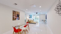 This 2-bedroom, 2-bathroom unit at The Helen in Memphis, TN offers a thoughtfully designed single-floor layout with clean, contemporary finishes throughout. The open-concept living and dining area is anchored by gleaming white tile floors, recessed lighting, and a ceiling fan, creating a bright and airy atmosphere. A sliding glass door floods the space with natural light and leads to a private balcony overlooking lush greenery. The kitchen is well-appointed with white shaker cabinetry, dark granite countertops, a classic subway tile backsplash with decorative accents, and a full suite of stainless steel appliances. A hallway connects the living areas to the two bedrooms, both of which feature plush carpeting and ceiling fans. The primary bedroom includes a sliding glass door to the balcony and a closet, while the second bedroom also offers closet storage. Both bathrooms showcase marble-surround finishes — one with a tub-shower combination and the other with a frameless glass walk-in shower. The unit is completed by a welcoming hallway with high-gloss tile flooring, offering a polished entry experience throughout this stylish Memphis residence.
