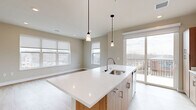 Located at 430 S Yellowstone Dr in Madison, WI, this thoughtfully designed 2-bedroom, 2-bathroom residence offers a well-organized single-floor layout with modern finishes throughout. The open-concept kitchen serves as the heart of the home, showcasing a substantial center island with a quartz countertop, undermount sink, and pendant lighting. Warm wood cabinetry pairs with stainless steel appliances, and a sliding glass door leads to a private balcony with outdoor views. Light wood-style flooring flows through the main living areas, lending a clean, contemporary feel. The primary bedroom is a comfortable retreat featuring a wide picture window with neighborhood views, soft carpeting, and access to a walk-in closet outfitted with wire shelving. The primary bathroom features a floating wood vanity, a tall storage cabinet, backlit mirror, and wood-look flooring. The second bedroom also offers plush carpeting, a ceiling fan, and a bright window with exterior views. A second full bathroom includes a tub-shower combo, wood-toned vanity with quartz countertop, and wood-look tile flooring. A clean, well-lit hallway with recessed lighting connects all rooms, completing this polished and functional residence.