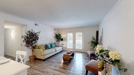 Located at 59 Stapleford Way in Hampton, Virginia, this single-floor, 2-bedroom, 2-bathroom home offers a thoughtfully designed layout with modern finishes throughout. Wood-look flooring runs continuously across the living spaces, adding warmth and visual cohesion.

The combined living and dining area is bright and welcoming, anchored by a set of classic French doors that flood the room with natural light and provide outdoor access. The kitchen features crisp white shaker-style cabinetry, granite-look countertops, stainless steel appliances including a dishwasher and range, and track lighting overhead — a functional and stylish space for everyday use.

The spacious primary bedroom offers a generous footprint with a dedicated walk-in closet, a window with outdoor views, and ample room for a full furniture arrangement. The second bedroom is cozy and well-proportioned, also featuring wood-look flooring and a closet. Both bathrooms are clean and bright with tiled tub-shower combinations and white fixtures. Additional features include in-unit laundry, four closets for storage, and a hallway connecting the private areas of the home. The overall ambiance is light, neutral, and move-in ready.