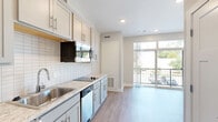 Located at 525 Clancy Ave NE in Grand Rapids, Michigan, this thoughtfully designed studio offers a smart, efficient floor plan that maximizes every square foot. The open-concept living area seamlessly connects the kitchen, dining, and living spaces, creating a cohesive and functional environment. Light-toned luxury vinyl plank flooring runs throughout, lending a clean, contemporary feel to the entire unit.

The kitchen is a standout feature, outfitted with crisp white shaker-style cabinetry, brushed gold hardware, granite-look countertops, and a classic white subway tile backsplash. Stainless steel appliances — including a microwave, dishwasher, and electric cooktop — are complemented by an in-unit washer, adding everyday convenience. The living area is anchored by a built-in murphy bed with an integrated sofa, offering flexible use of the space. A large sliding glass door floods the room with natural light and opens to a private balcony with outdoor views.

Two closets provide ample storage throughout the unit. The bathroom features a granite-top vanity with under-cabinet storage, a glass-enclosed walk-in shower, and wood-look flooring that ties the space together. Recessed lighting throughout keeps the interior bright and modern. This well-appointed studio is ideal for those seeking a stylish, low-maintenance living space in Grand Rapids.
