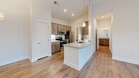 Located at 418 Battery Park Circle in Pendleton, South Carolina, this single-story, one-bedroom, one-bathroom residence offers a thoughtfully designed layout across a comfortable footprint. The open-concept living, dining, and kitchen area serves as the heart of the home, anchored by wood-look plank flooring that flows throughout the main spaces. The kitchen is well-equipped with stainless steel appliances, including an electric range, microwave, refrigerator, and dishwasher. Warm-toned cabinetry pairs with granite countertops, and a peninsula with pendant lighting provides additional workspace and a casual dining option. Recessed lighting illuminates the kitchen, while a dedicated utility room just off the kitchen houses an in-unit washer.

The living room is bright and airy, benefiting from multiple windows and a glass-paned door that invite natural light and outdoor views of the surrounding greenery. A ceiling fan adds comfort to this space. The bedroom, finished with plush carpet, also features a ceiling fan, a closet, and a window. The full bathroom is clean and modern, offering a tub-shower combination, wood-look flooring, a granite-topped vanity, and wood-toned cabinetry consistent with the rest of the unit's design aesthetic.