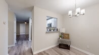 Located at 1150 Sigman Rd NE in Conyers, Georgia, this single-floor home offers a thoughtfully designed layout with a clean, modern aesthetic throughout. The living room serves as the heart of the home, showcasing wood-look flooring, a ceiling fan with light fixture, a sleek fireplace, and French doors that invite natural light and outdoor views. The kitchen is well-equipped with white shaker-style cabinetry, granite countertops, stainless steel appliances including a refrigerator, range, and microwave, and wood-look flooring. A pass-through window connects the kitchen to the dining area, which is complemented by a stylish chandelier. The bedrooms feature plush carpeting and ample natural light from windows with views of surrounding greenery. At least one bedroom includes a spacious walk-in closet with wire shelving for convenient storage. The bathroom is appointed with a tub-shower combination and clean, neutral finishes. Throughout the home, a consistent neutral color palette and textured ceilings create a cohesive and inviting ambiance, making this a comfortable and functional single-floor residence.