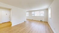 Located at 8000 High School Rd in Elkins Park, PA, this one-bedroom, one-bathroom residence offers a well-organized single-floor layout designed for comfortable everyday living. The living room is a bright, open space featuring light hardwood-style flooring and a trio of windows that allow generous natural light to fill the room, offering views of the surrounding exterior. The space maintains a clean, neutral palette throughout, creating a calm and versatile ambiance.

The galley-style kitchen is efficiently designed with warm wood cabinetry lining both sides, a tile backsplash, dark countertops, and a full suite of white appliances including a gas range, refrigerator, dishwasher, and microwave. Light hardwood flooring continues through the kitchen, connecting seamlessly to the hallways.

The spacious primary bedroom is carpeted in a neutral tan tone, offering a cozy and quiet retreat with a window providing natural light. A second carpeted room provides additional flexible space. Two hallways connect the rooms, adding to the unit's practical flow.

The bathroom features white tile wainscoting, a white vanity with an under-sink cabinet, a mirrored medicine cabinet, and bright overhead lighting, giving it a clean and functional finish. Overall, this residence offers a straightforward and well-maintained layout suited for efficient, comfortable living.
