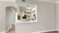 This well-appointed one-bedroom, one-bathroom unit in Round Rock, Texas offers a functional and modern layout across a single floor. The open-concept kitchen and living area serves as the heart of the home, connected by a pass-through window with a built-in breakfast bar. The kitchen is outfitted with white shaker cabinetry, white quartz countertops, a classic subway tile backsplash, stainless steel appliances including a refrigerator, range, microwave, and dishwasher, and warm wood-style vinyl plank flooring that flows throughout the unit. Crown molding adds a refined touch to the living spaces. The bedroom is a comfortable retreat featuring wood-style flooring, crown molding, a ceiling fan, and large windows with blinds that invite ample natural light. The full bathroom includes a white vanity with cabinet storage, a tub-shower combination, and matching wood-style flooring. A dedicated laundry room provides added convenience with a full-size washer and dryer. The unit also includes an attached single-car garage with an automatic opener, offering secure parking and additional storage. The overall aesthetic is clean, bright, and modern throughout.