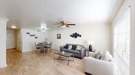 This two-story residence in Baton Rouge, Louisiana offers a well-organized layout across two floors, combining functional design with clean, modern finishes. Light wood-style flooring flows throughout the main living areas, creating a warm and cohesive aesthetic.

The open-concept main floor seamlessly connects the living room and dining area. The living room features crown molding, a ceiling fan, and large windows that allow ample natural light to fill the space. The adjacent dining area includes its own stylish chandelier and crown molding detail, adding a refined touch.

The kitchen is well-appointed with white shaker-style cabinetry, white subway tile backsplash, light countertops, a double-basin sink positioned beneath a window, and a black electric range with overhead ventilation.

A convenient half-bathroom is located on the main floor, featuring a marble-look countertop vanity and a framed mirror.

Upstairs, both bedrooms offer ceiling fans and light wood flooring. One bedroom features a large picture window with views of lush outdoor greenery, providing a serene atmosphere. The bedrooms include closet storage, and the full bathroom provides a clean, functional vanity with framed mirror. The overall ambiance is bright, tidy, and move-in ready.