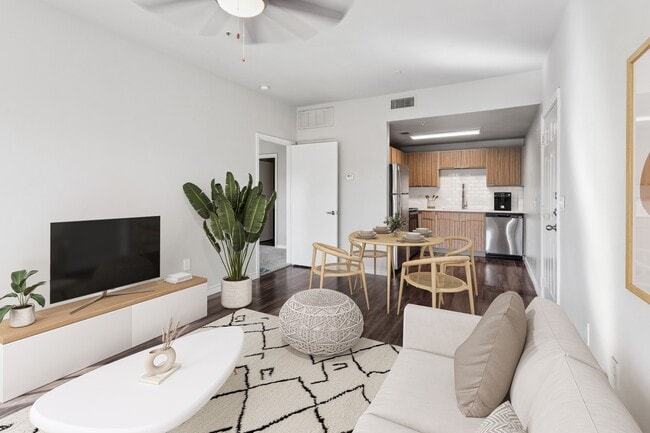 Spacious living room with renovated kitchen finishes - Azul Apartment Homes