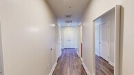 Located at 699 N Broad St in Philadelphia's vibrant Northern Liberties neighborhood, this well-appointed 4-bedroom, 2-bathroom unit offers a thoughtfully designed single-floor layout. The open-concept living area features hardwood-style flooring, warm neutral tones, and a striking arched window that frames sweeping city views and fills the space with natural light. A second arched window offers charming views of the surrounding historic brick architecture. The kitchen is equipped with warm-toned cabinetry, granite countertops, a breakfast bar, stainless steel appliances including a refrigerator, range, and microwave, plus pendant lighting and an additional arched window for natural light. Two well-lit hallways connect the four bedrooms, each featuring plush carpeting and generous double closet storage — with seven closets total throughout the unit. The primary bedroom provides a comfortable, private retreat. Both bathrooms are clean and functional, with one featuring a tub-shower combination lined in classic white subway tile. A dedicated laundry area adds everyday convenience. The space balances modern finishes with architectural character, making it a practical and attractive option in central Philadelphia.