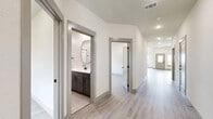 Located at 13557 Bonanza Cir in Cresson, TX, this well-appointed single-story home offers a thoughtfully designed layout with 3 bedrooms and 3 bathrooms across a generously sized floor plan. The open-concept living room and kitchen area serves as the heart of the home, featuring soaring vaulted ceilings, recessed lighting, and large windows that fill the space with natural light while providing views of the fenced backyard. Light-toned wood-look flooring flows throughout the main living areas and bedrooms, lending a clean, contemporary feel. The modern kitchen is equipped with gray shaker-style cabinetry, white quartz countertops, a tile backsplash, stainless steel appliances including a refrigerator, range, microwave, and dishwasher, plus a central island and an undermount sink. The primary bedroom is spacious and features vaulted ceilings, while its en-suite bathroom impresses with a dual-sink vanity with gray cabinetry, black hardware accents, a framed glass walk-in shower with marble-style tile, and light tile flooring. Additional bedrooms are bright and well-sized with ceiling fans. The dedicated laundry room includes a washer and dryer and tile flooring. A large attached two-car garage with an automatic opener rounds out this move-in-ready home.