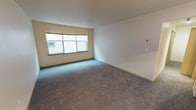 Located at 620 N 34th Street in Seattle's vibrant Fremont neighborhood, Unit 226 is a single-floor residence offering a clean, move-in-ready layout. The living area is finished with wall-to-wall carpet in a neutral tone, providing a comfortable and quiet underfoot experience. A large window with a roller blind allows natural light to fill the room while offering flexible light control. The walls are painted in a soft, neutral cream that complements the carpeting and contributes to a bright, open atmosphere. Electrical outlets and a thermostat control panel are thoughtfully positioned along the walls, ensuring functional convenience throughout the space. The understated design keeps the interior versatile, making it easy to personalize and furnish to a variety of tastes. Situated in Fremont — one of Seattle's most walkable and culturally rich neighborhoods — the unit offers convenient access to local dining, shopping, parks, and public transit, making it an ideal base for those looking to enjoy all that the area has to offer.
