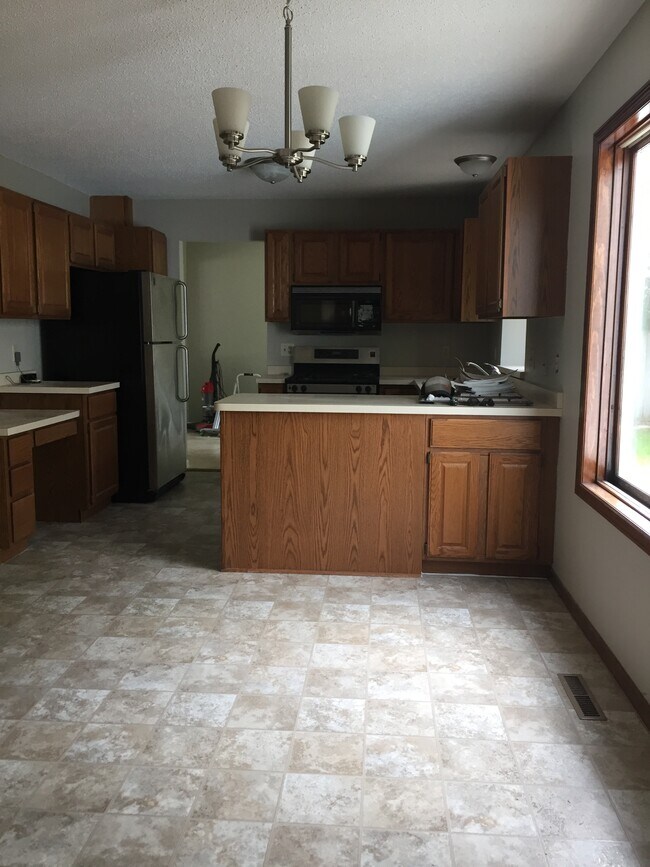 Open kitchen looks onto family room, stainless steel appliances - 14627 Hanover Ln