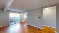 Located at 6700 Telephone Rd in Ventura, California, this single-floor unit offers a well-organized layout with a functional and clean aesthetic throughout. The living area is spacious and bright, featuring warm wood-look laminate flooring, neutral gray walls, and a textured ceiling. Vertical blinds along a sliding glass door allow natural light to pour in while providing privacy and access to the outdoors. A ceiling fan adds comfort to the adjoining area, which connects seamlessly to the rest of the unit. The galley-style kitchen is efficiently designed with ample white cabinetry, light stone-look countertops, a gas range, dishwasher, refrigerator, and a single-basin sink. A window above the counter brings in additional natural light, keeping the space bright and airy. The bedrooms are carpeted in a neutral tan tone, offering a comfortable and quiet retreat, each with windows dressed in vertical blinds. The unit includes two bathrooms — one featuring a standalone walk-in shower with chrome fixtures, and the other equipped with a full tub-shower combination. Clean white finishes carry throughout both bathrooms. The overall design is practical and move-in ready, making this Ventura unit a straightforward and comfortable living space.