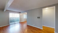 Located at 6700 Telephone Rd in Ventura, California, this single-floor unit offers a well-organized layout with a functional and clean aesthetic throughout. The living area is spacious and bright, featuring warm wood-look laminate flooring, neutral gray walls, and a textured ceiling. Vertical blinds along a sliding glass door allow natural light to pour in while providing privacy and access to the outdoors. A ceiling fan adds comfort to the adjoining area, which connects seamlessly to the rest of the unit. The galley-style kitchen is efficiently designed with ample white cabinetry, light stone-look countertops, a gas range, dishwasher, refrigerator, and a single-basin sink. A window above the counter brings in additional natural light, keeping the space bright and airy. The bedrooms are carpeted in a neutral tan tone, offering a comfortable and quiet retreat, each with windows dressed in vertical blinds. The unit includes two bathrooms — one featuring a standalone walk-in shower with chrome fixtures, and the other equipped with a full tub-shower combination. Clean white finishes carry throughout both bathrooms. The overall design is practical and move-in ready, making this Ventura unit a straightforward and comfortable living space.