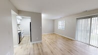 This 2-bedroom, 1-bathroom unit at Vineyards Apartments in Indianapolis, Indiana offers a clean, modern aesthetic throughout its efficiently designed single-floor layout. The open living area features light wood-style luxury vinyl plank flooring, neutral gray walls, and white trim, creating a bright and cohesive atmosphere. A sliding glass door floods the living room with natural light and provides access to the outdoors. The galley-style kitchen is well-appointed with white cabinetry featuring black hardware, light countertops, a double-basin sink with a matte black faucet, and stainless steel appliances including a refrigerator, range, and dishwasher. Both bedrooms are carpeted in a warm neutral tone and include windows that allow natural light to filter in. The primary bedroom is generously sized and features two closets, offering ample storage. The secondary bedroom includes a built-in closet as well. The full bathroom is finished with a white tub-shower combo and matte black fixtures, maintaining the consistent modern styling found throughout the unit. Clean lines, neutral tones, and updated finishes make this a comfortable and move-in-ready home.