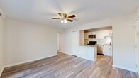 Located at 890 W Loveland Ave in Loveland, Ohio, this single-floor residence offers three bedrooms, one bathroom, and a practical, well-organized layout. The open-concept living area features light wood-look flooring and a ceiling fan, flowing seamlessly into the kitchen. The kitchen is equipped with white cabinetry, granite countertops, a subway tile backsplash, and a full suite of stainless steel appliances including a range, microwave, and refrigerator, with a peninsula providing additional counter space. A sliding glass door in one room opens to a private balcony, bringing in natural light and outdoor views of the surrounding greenery. The bedrooms include a generously sized primary bedroom with a ceiling fan and closet, while the additional bedrooms feature plush carpeting and bright windows. Four closets throughout the unit provide ample storage. The bathroom is finished with clean white subway tile surrounding a full soaking tub and shower combo with brushed gold fixtures. An in-unit laundry area adds everyday convenience. Neutral tones and consistent finishes throughout give the space a cohesive, move-in-ready feel.