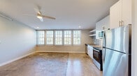 This 2-bedroom, 1-bathroom unit in Memphis, Tennessee offers a compelling mix of industrial loft character and modern finishes. Polished concrete floors run throughout the space, lending an urban aesthetic that pairs well with the clean, neutral color palette on the walls. The open-concept kitchen and living area forms the heart of the unit, highlighted by a row of large, grid-pane windows fitted with horizontal blinds that flood the space with natural light and offer leafy outdoor views. A ceiling fan with integrated lighting adds comfort and functionality overhead, while exposed ductwork contributes to the loft-inspired design.

The kitchen is well-equipped with stainless steel appliances — including a refrigerator, range, microwave, and dishwasher — white cabinetry, open shelving, and a stainless sink. The primary bedroom is generously proportioned, featuring multiple large windows that continue the theme of abundant natural light. A second bedroom with a sloped ceiling provides a cozy, loft-like feel with its own closet access. The bathroom is finished with white subway tile in a glass-enclosed walk-in shower, hexagonal mosaic tile flooring, and clean, contemporary fixtures. A dedicated closet and hallway round out this thoughtfully laid-out unit.
