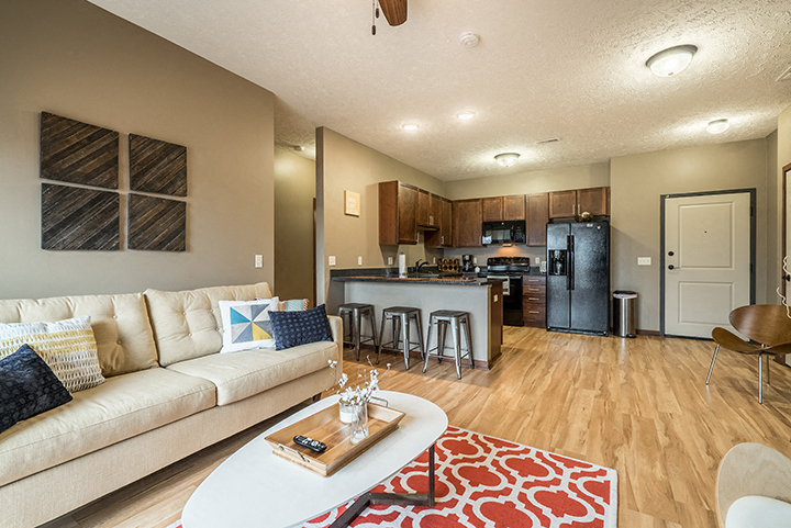 Open-concept living space with hardwood-like flooring. - Villas of Omaha at Butler Ridge