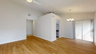 Located at 535 Village Lane in Winter Park, Florida, this single-floor residence offers a clean, light-filled interior with a thoughtfully designed layout. The main living area is anchored by warm hardwood flooring and soaring vaulted ceilings, which lend an open, airy quality to the space. A chandelier adds a refined touch to the dining area, while track lighting is positioned overhead near the kitchen entry. Vertical blinds along sliding glass doors allow abundant natural light to filter through while providing privacy.

The galley-style kitchen is well-appointed with white shaker cabinetry, granite countertops, a herringbone tile backsplash, a stainless steel sink with a brushed gold faucet, and tile flooring. It opens toward the dining area, creating a functional flow between spaces.

The bedrooms feature plush carpeting, ceiling fans, and access to natural light through windows and sliding glass doors—one bedroom offering an outdoor view through a full-length glass panel. Closet space is provided via louvered doors.

The bathrooms are finished with granite-topped white vanities, brushed gold fixtures, framed mirrors, and neutral tile flooring, contributing to a consistently clean and cohesive aesthetic throughout the home.