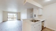 Located at 1730 N Community Dr in Anaheim, CA, this 1-bedroom, 1-bathroom unit offers a well-organized, efficient layout across a single floor. The open-concept living, dining, and kitchen area serves as the heart of the home, where light-toned hardwood-style flooring runs seamlessly throughout, enhancing the bright and airy atmosphere. The kitchen features white shaker-style cabinetry, light quartz countertops, a double stainless steel sink, a dishwasher, and stainless steel appliances including an electric range with overhead microwave. A peninsula counter connects the kitchen to the living and dining area, creating a natural flow ideal for everyday living. The spacious living room is filled with natural light from a large sliding glass door that opens onto a private balcony with outdoor views. A ceiling fan adds comfort to the room. The bedroom is a generously sized retreat with a natural light window fitted with vertical blinds, and easy access to a dedicated closet. The bathroom is conveniently positioned off the hallway. A textured ceiling is present in select areas of the unit. The clean, neutral palette throughout creates a move-in ready environment suited for a variety of lifestyles.
