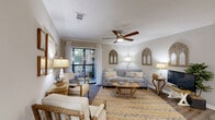 Located at 800 Runaway Bay Lane in Mount Pleasant, South Carolina, this well-appointed two-bedroom, two-bathroom residence offers a thoughtfully designed single-floor layout. The open-concept living, dining, and kitchen area serves as the heart of the home, with hardwood-style flooring flowing throughout. The living room features crown molding, a ceiling fan, and a sliding glass door that opens to a private balcony, filling the space with natural light and offering pleasant outdoor views. The galley-style kitchen is outfitted with white cabinetry, granite countertops, stainless steel appliances, and a deep undermount sink. The adjacent dining area provides a welcoming space for entertaining. The primary bedroom is a comfortable retreat with soft carpet, ample closet space, and an en-suite bathroom featuring a granite-topped vanity, white cabinetry, and a tiled tub/shower combination. The second bedroom is similarly well-sized with natural light and its own closet access. A second full bathroom mirrors the same refined finishes. Additional conveniences include a dedicated laundry area, utility room, and multiple closets throughout. The neutral color palette and coastal-inspired accents lend the space a calm, inviting ambiance.