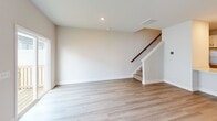 Located in Burlington, NC, this two-story home offers a well-designed layout across two floors. The main level features an open-concept kitchen and living area with light hardwood-style flooring and recessed lighting throughout. The kitchen is outfitted with white shaker cabinets, black hardware, light quartz countertops, a subway tile backsplash, stainless steel appliances, and a peninsula with an undermount sink — ideal for both cooking and entertaining. The living area is bright and open, with a staircase with a wood railing leading to the upper level.

Upstairs, three bedrooms provide comfortable accommodations, with plush carpet flooring and windows that bring in natural light. The spacious primary bedroom features sliding glass doors opening to a private deck, adding an outdoor retreat. The primary bathroom includes a glass-enclosed walk-in shower with tile surround, a white vanity with quartz countertops, and hardwood-style flooring. Three full bathrooms serve the home in total. Two closets provide dedicated storage space throughout.

The attached garage includes an automatic opener and a direct interior access door. The home's clean, neutral palette and modern finishes create a cohesive, move-in-ready atmosphere throughout.