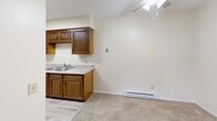 Located at 4120 Terrace View S Rd in Toledo, Ohio, this single-floor residence offers two bedrooms and one bathroom within a practical and efficiently arranged layout. The kitchen is a standout feature, equipped with rich dark wood cabinetry, granite-style countertops, white appliances including a refrigerator and electric range, and a double stainless steel sink. Light wood-style flooring runs through the kitchen, which is brightened by a skylight overhead. The kitchen opens toward the main living area, which is highlighted by a ceiling fan and transitions seamlessly into the carpeted living space. The spacious primary bedroom accommodates a generous footprint and features a large sliding glass door with vertical blinds, allowing for natural light and outdoor access. Both bedrooms are carpeted, with the second bedroom featuring a window with blinds and a wall-mounted air conditioning unit alongside baseboard heating. Each bedroom includes a sliding wood-panel closet. The bathroom is clean and functional, featuring a full-sized tub and shower combination with chrome fixtures and safety bars. Baseboard heating is present throughout the unit, ensuring year-round comfort in this straightforward and well-maintained Toledo residence.